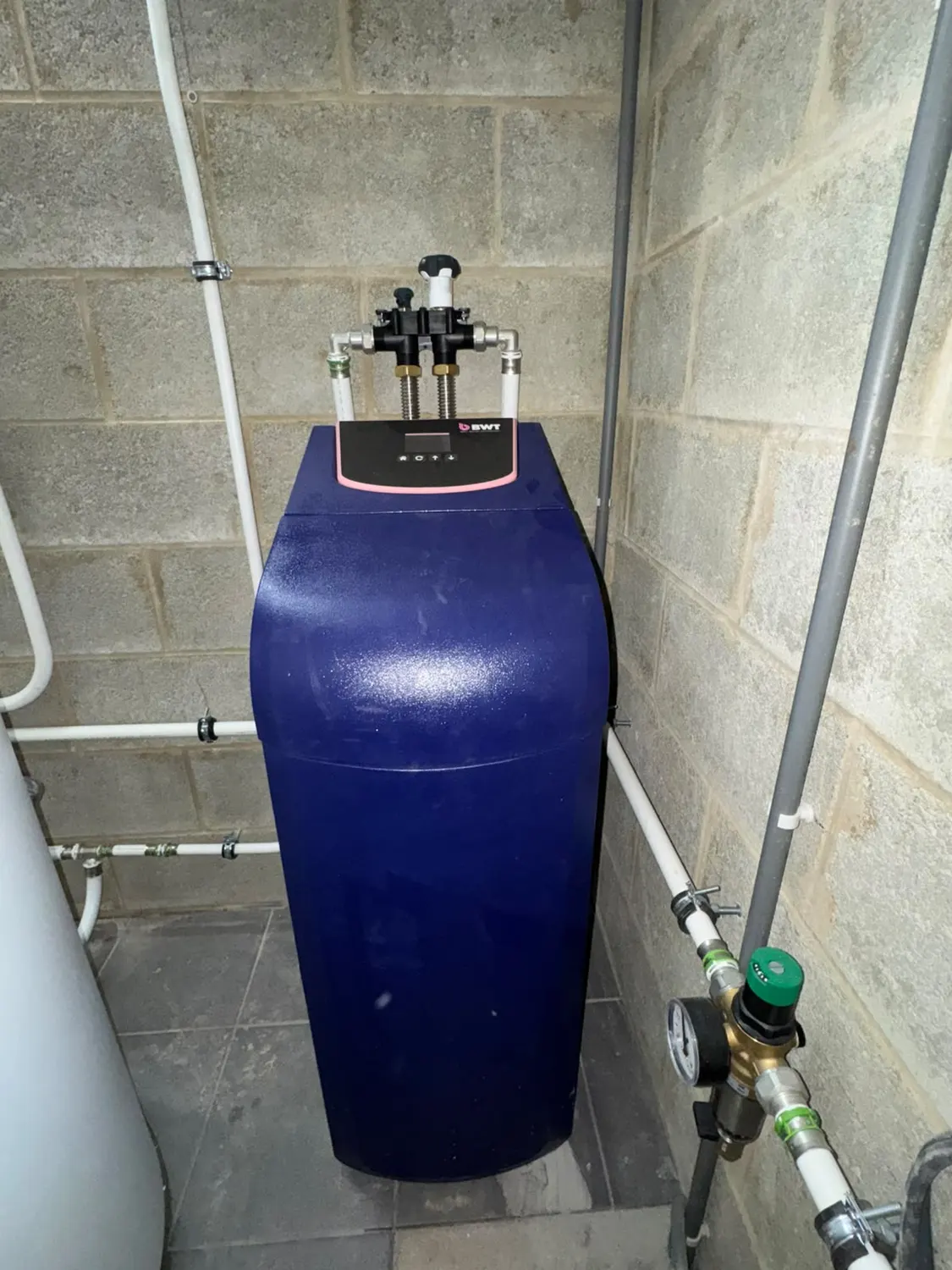 Adoucisseur d'eau à bac bleu installé dans un local technique