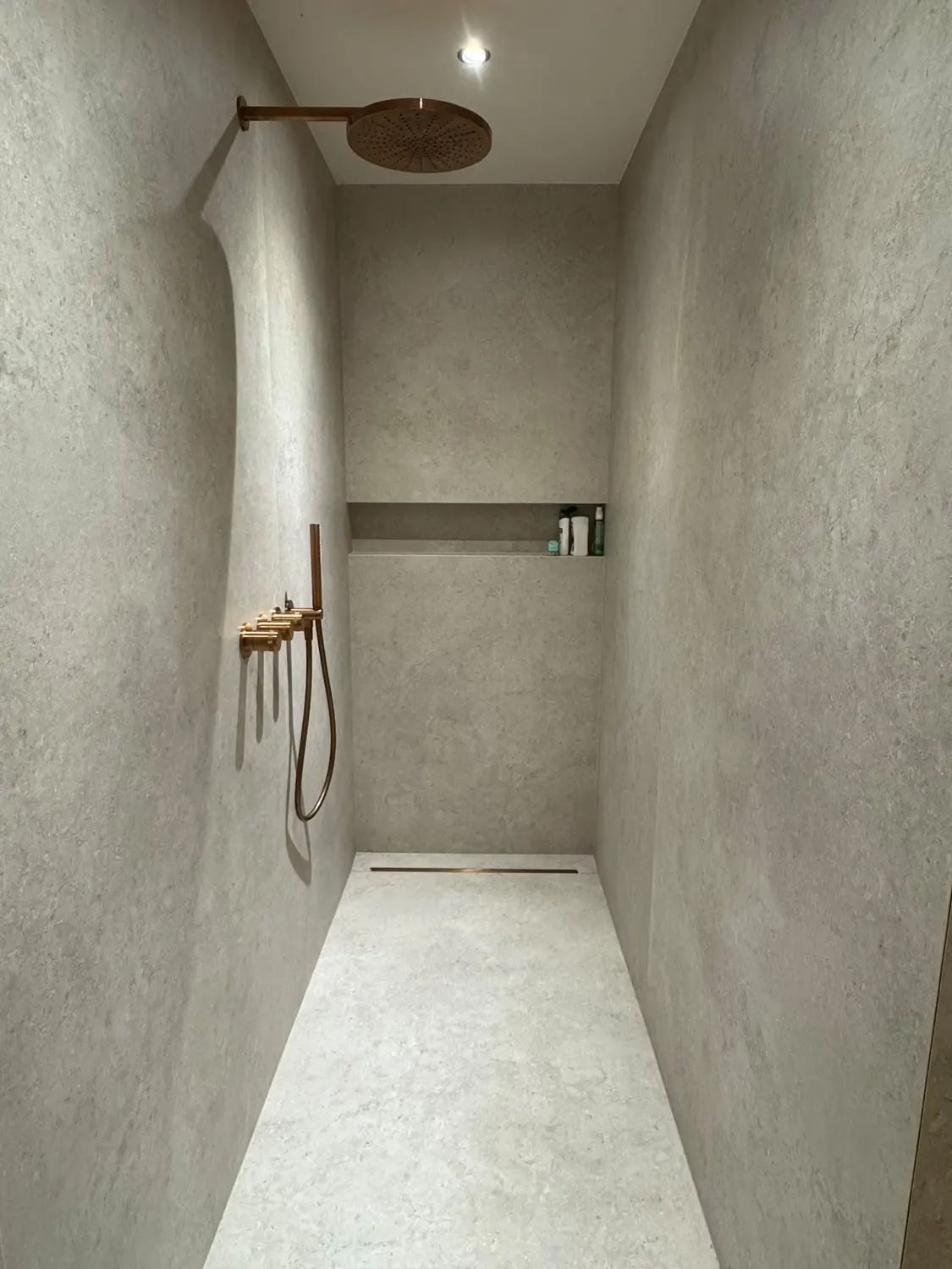 Douche à l'italienne en béton ciré avec colonne de douche