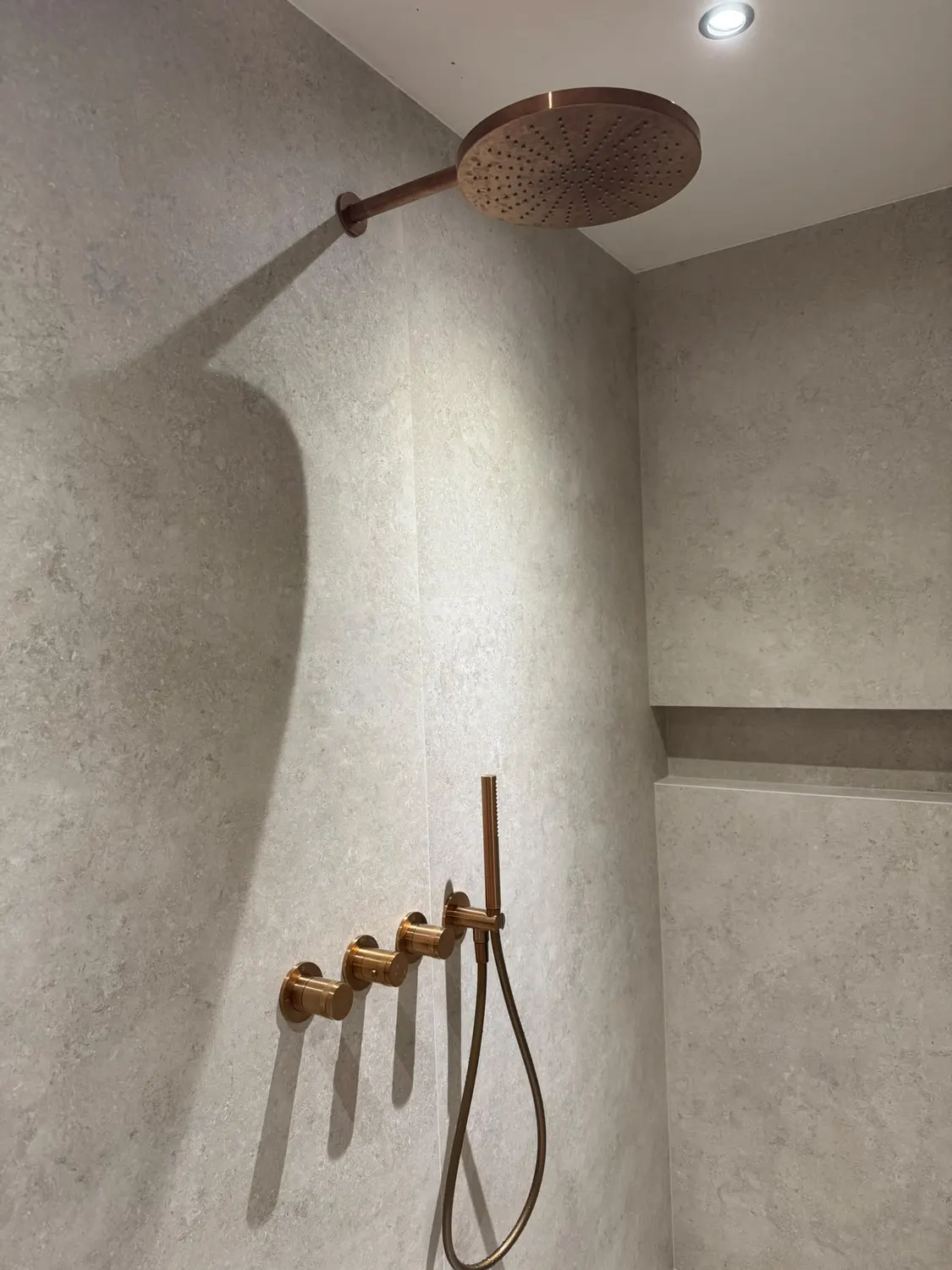 Douche à l'italienne en béton ciré aux lignes courbes, réalisée par ABL Chauffage