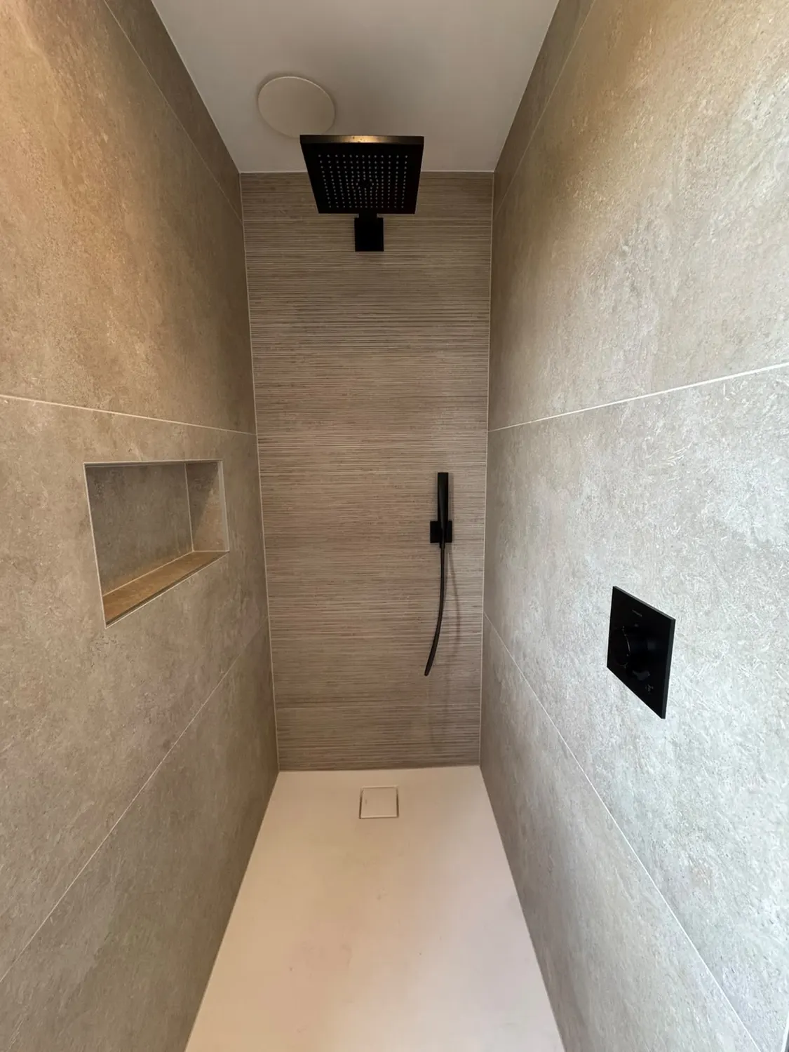Douche à l'italienne carrelée avec niche de rangement et mitigeur encastré