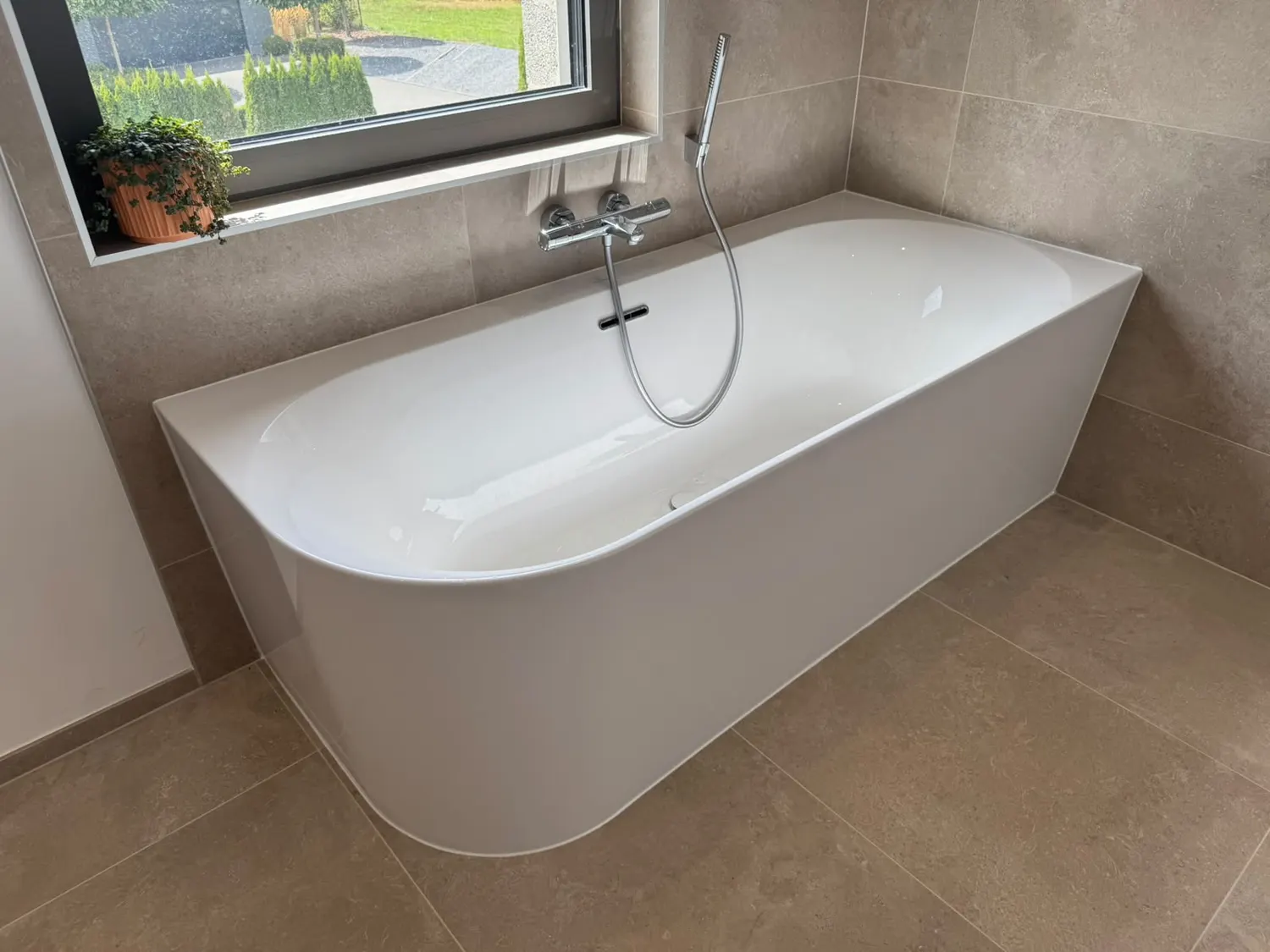 Baignoire îlot blanche dans une salle de bain moderne réalisée par ABL Chauffage