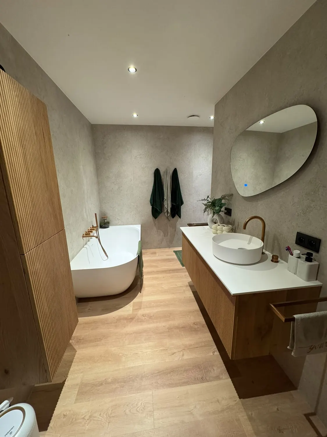 Meuble vasque en bois, vasque à poser et miroir rond dans une salle de bain design