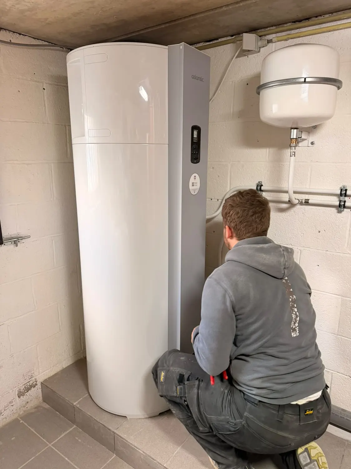 Technicien d'ABL Chauffage finalisant l'installation d'un boiler thermodynamique Atlantic
