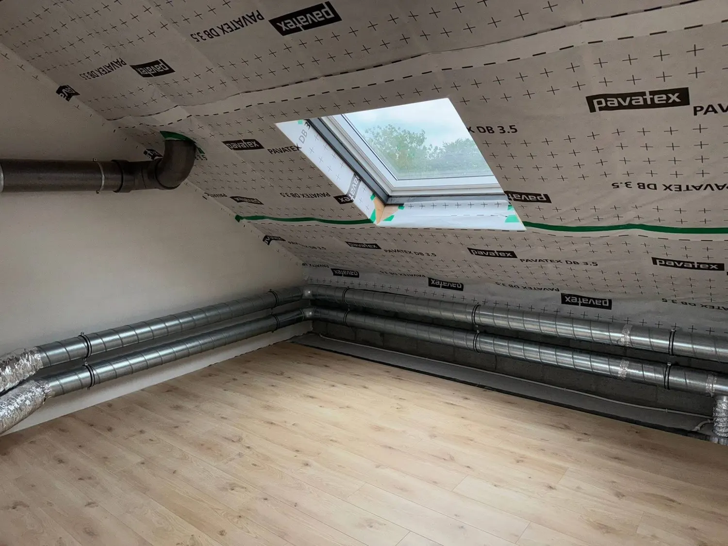 Réseau de gaines spiralées en combles aménagés, le long des murs, avec membrane Pavatex et fenêtre de toit